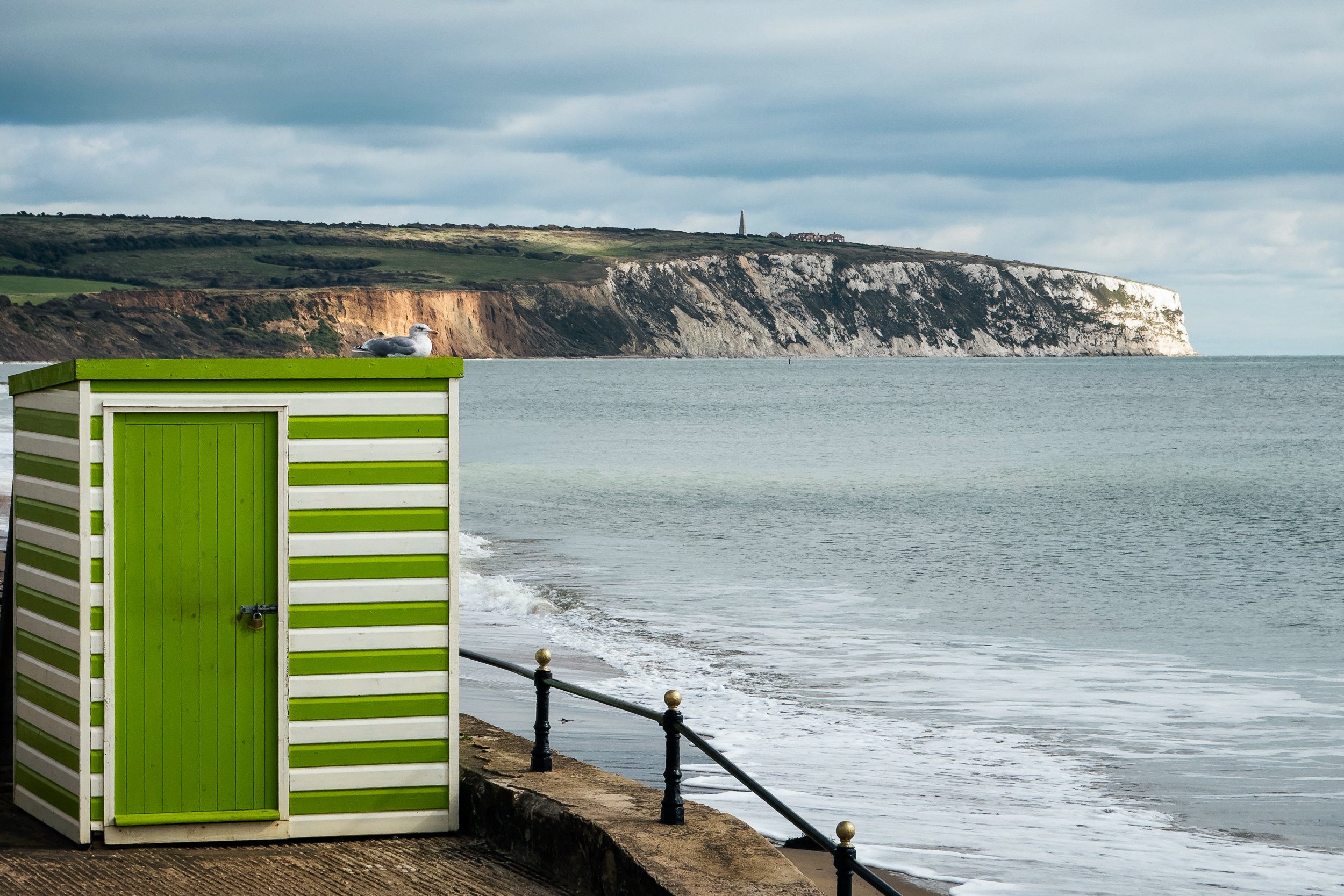 A stripey box sitting on a rock on the beach